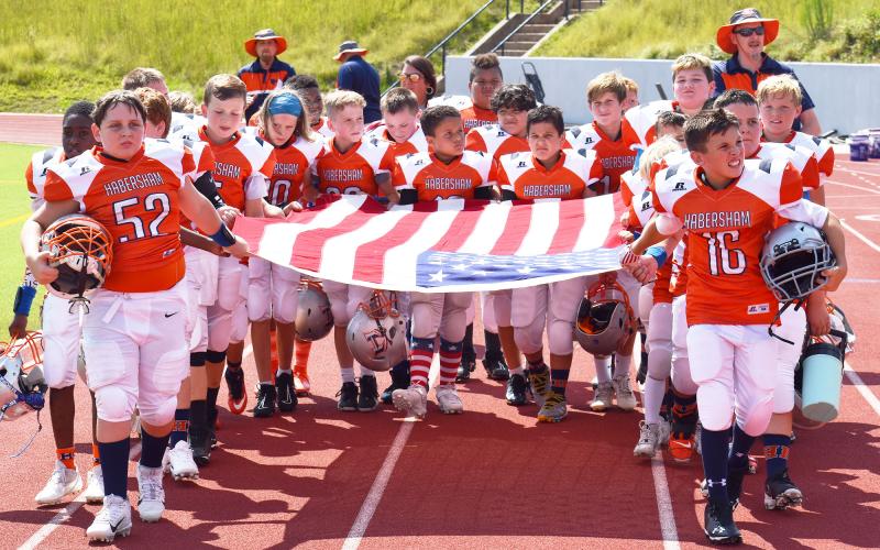 Habersham’s 10U football team members carry out an American flag before their game Saturday in honor of the 9/11 anniversary. MATTHEW OSBORNE/Staff
