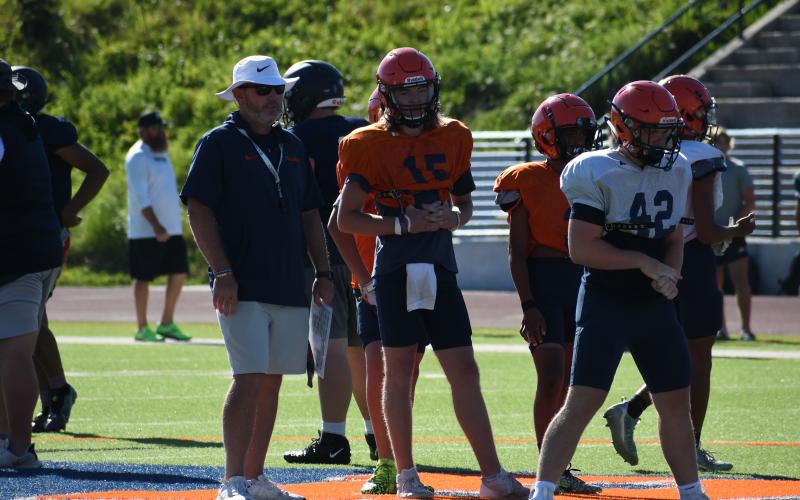 Coach Benji Harrison and quarterback DJ Pass look on as the second team lines up during padded camp. LANG STOREY/Staff
