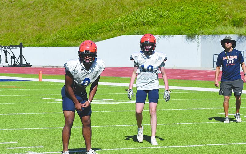 Donovan  Warren and Hudson Gailey get set of defense before a play against Hart County during padded camp this week. LANG STOREY/Staff