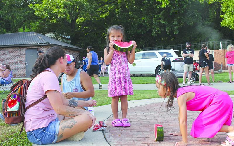 Samantha and Sergio Andres watch their kids Linda and Kylah devour watermelon at Baldwin’s Pit Nic Saturday. BRIAN WELLMEIER/Special